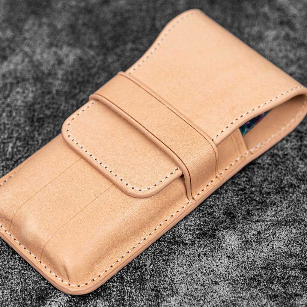 Undyed natural leather pen case on wooden surface