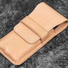 Undyed natural leather pen case on wooden surface