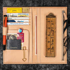 Open leather wallet with various cards and a ruler on a dark textured background