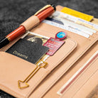 Open wallet insert with cards, a pen, and decorative elements on a textured surface