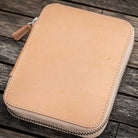 Natural undyed leather pen case with zipper on a wooden surface