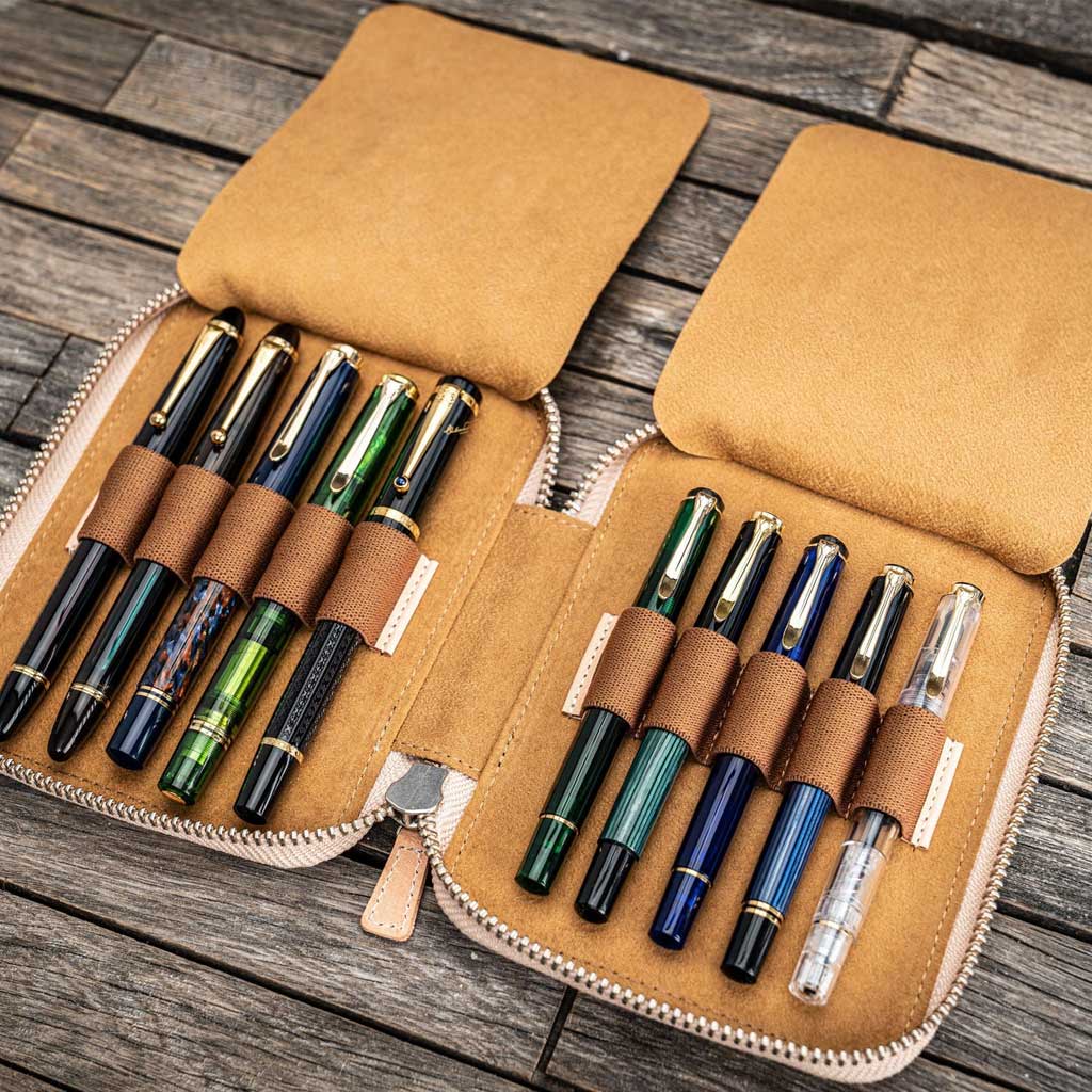 Natural undyed leather pen case with ten pens and zipper on a wooden surface