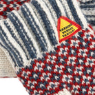 Close-up of a knitted product with a 'Warning Varma Vantar' patch.