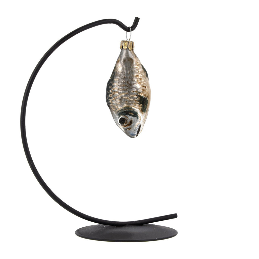 A glass carp ornament hung on black display piece.