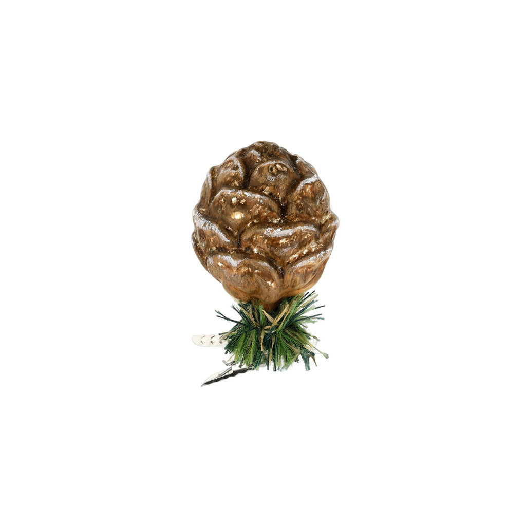 A glass pinecone ornament with green pine needles attached to metal clip.