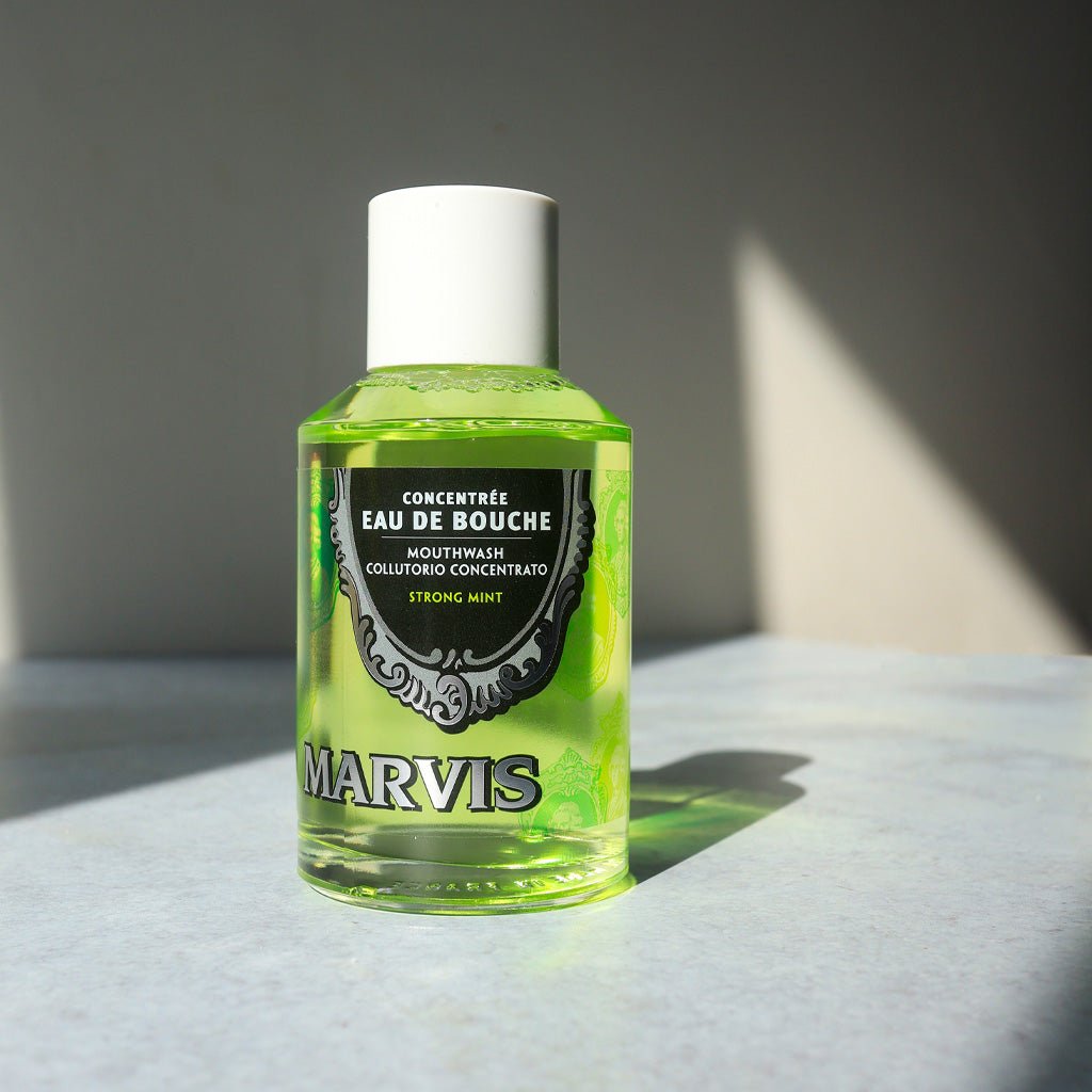 A bottle of mouthwash concentrate on a sunny bathroom counter.