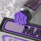Close-up of purple Marvis toothpaste tube cap on top of packaging.