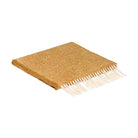 A folded woven scarf in a yellow color with white fringe.