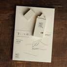 Midori cream correction tape resting on top of a Midori notebook