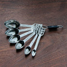 Set of metal measuring spoons on a wooden surface