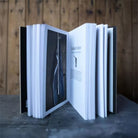 Open book with black and white pages in front of a wooden surface