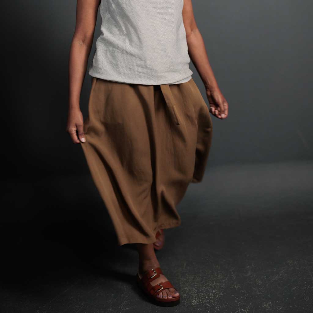Woman wearing merchant and mills sewn clothing against dark background
