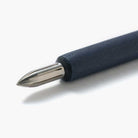Blue wooden dip pen with steel nib on white surface