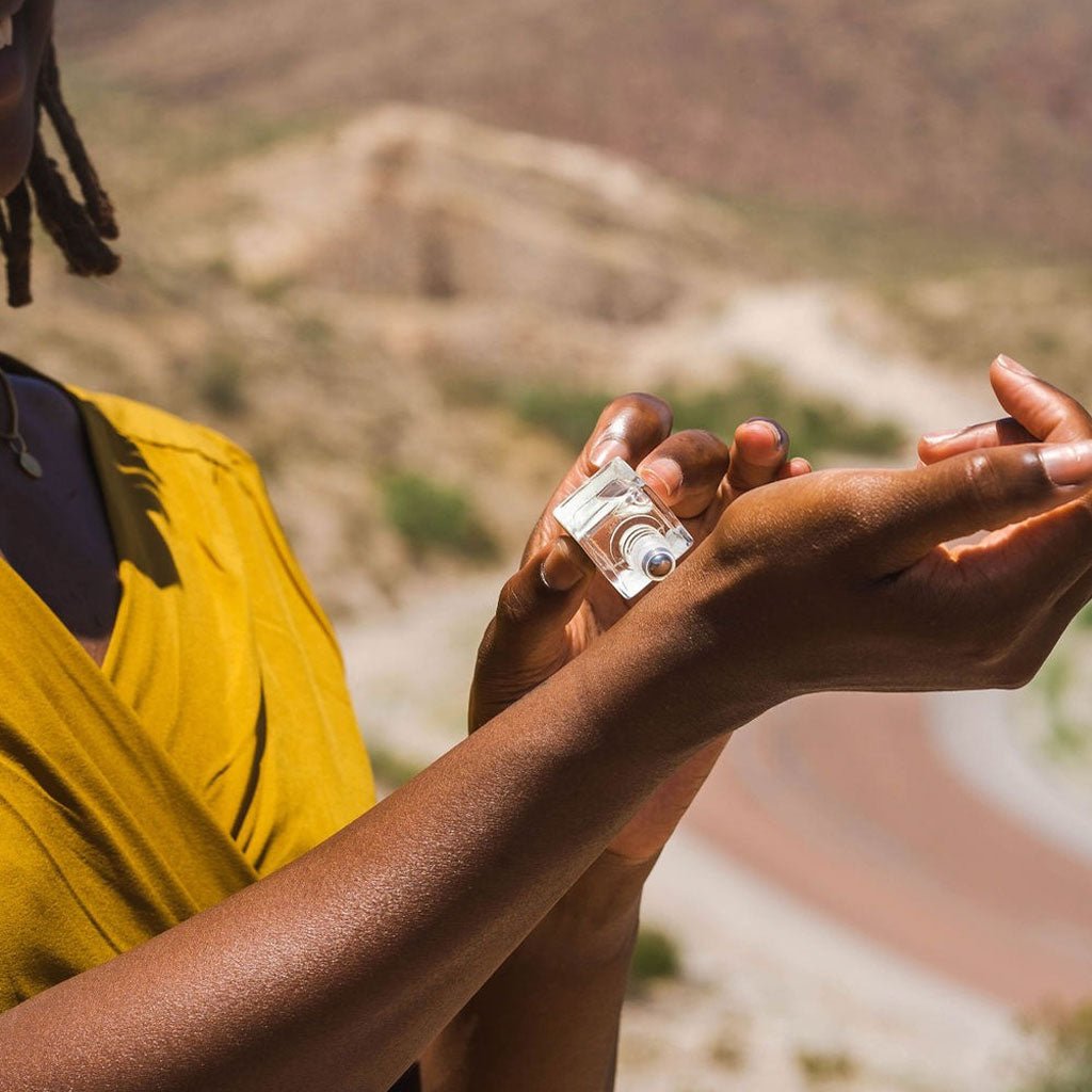 Person rolling perfume on their wrist 