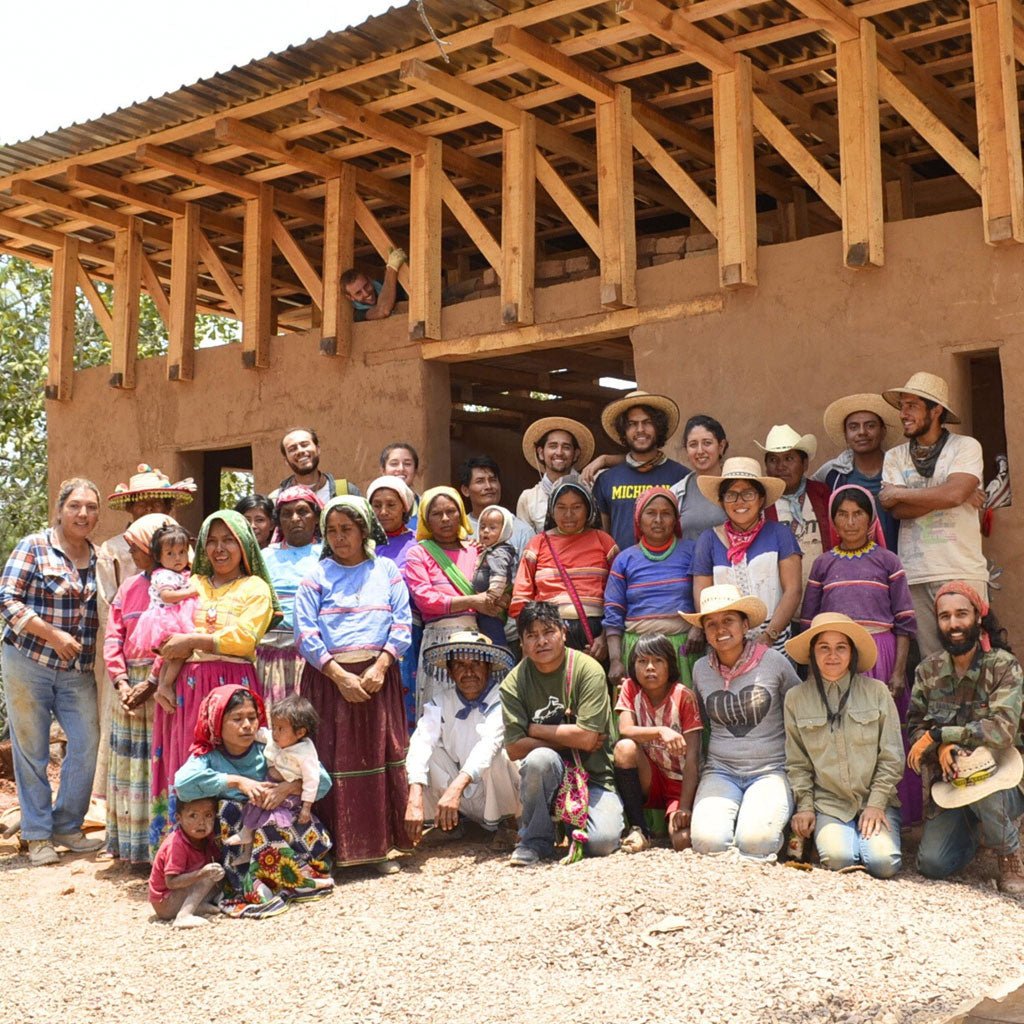 Group of people posing in front of a partially built structure
