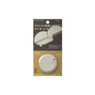 A round beige carton opener by Midori in packaging on white background