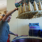Rory from Moorlands Candles hand dipping stumpie taper candles in workshop