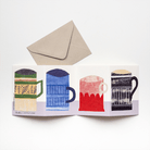 Accordion-style greeting card with four illustrated mugs in green, blue, red, and black, displayed open beneath a kraft paper envelope.