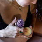 Person holding opened tin of nipple salve