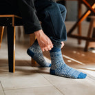 Model putting on blue and white wool jacquard socks.
