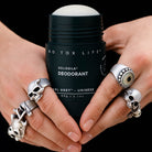 Hands holding an open tube of deodorant.