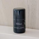 Black Earl Grey deodorant tube closed on bathroom shelf. 