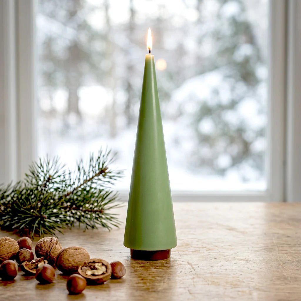 A lit sage green big candle tree on wooden table.