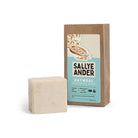 Bar of SallyeAnder unscented oatmeal essential soap on white background next to packaging