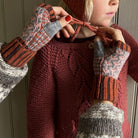 Hands wearing wool wrist warmers and tying children's bonnet.