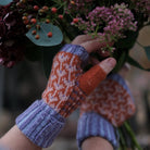 Hands wearing wool wrist warmers and holding bouquet of flowers.