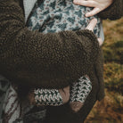 Child wearing patterned wool socks.