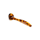 Tortoiseshell acrylic slotted spoon with curved stem on white background