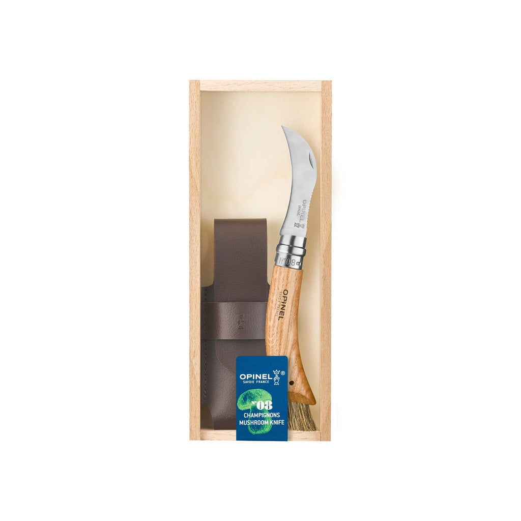 An Opinel folding mushroom knife with wooden handle and leather sheath inside wooden gift box with blue label on white background