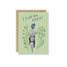 Green greeting card with father and child on bike illustration with kraft envelope on white background