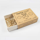 Yellow box of decorative brass wire paper clips on light surface