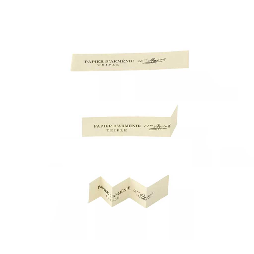 Papier d'Arménie incense paper strips being folded on white background