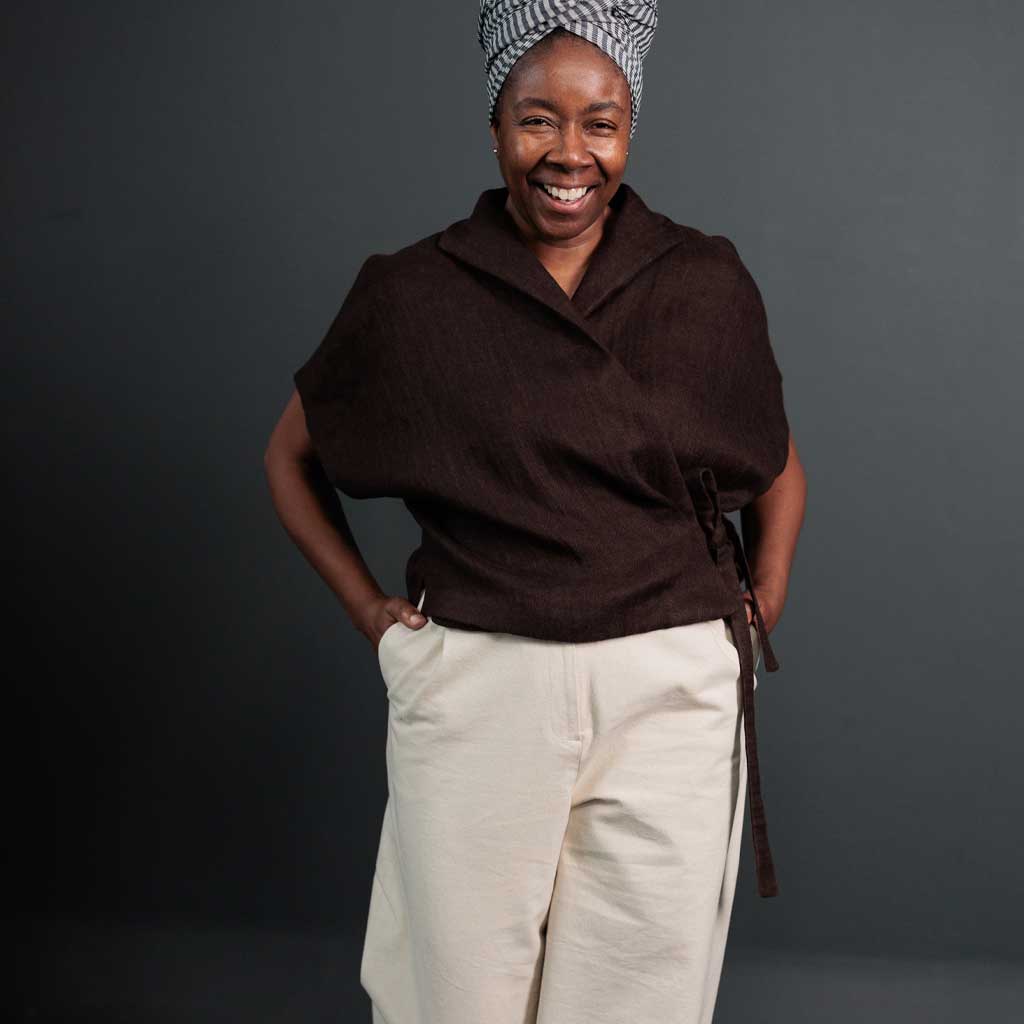 Woman wearing merchant and mills sewn clothing against dark background