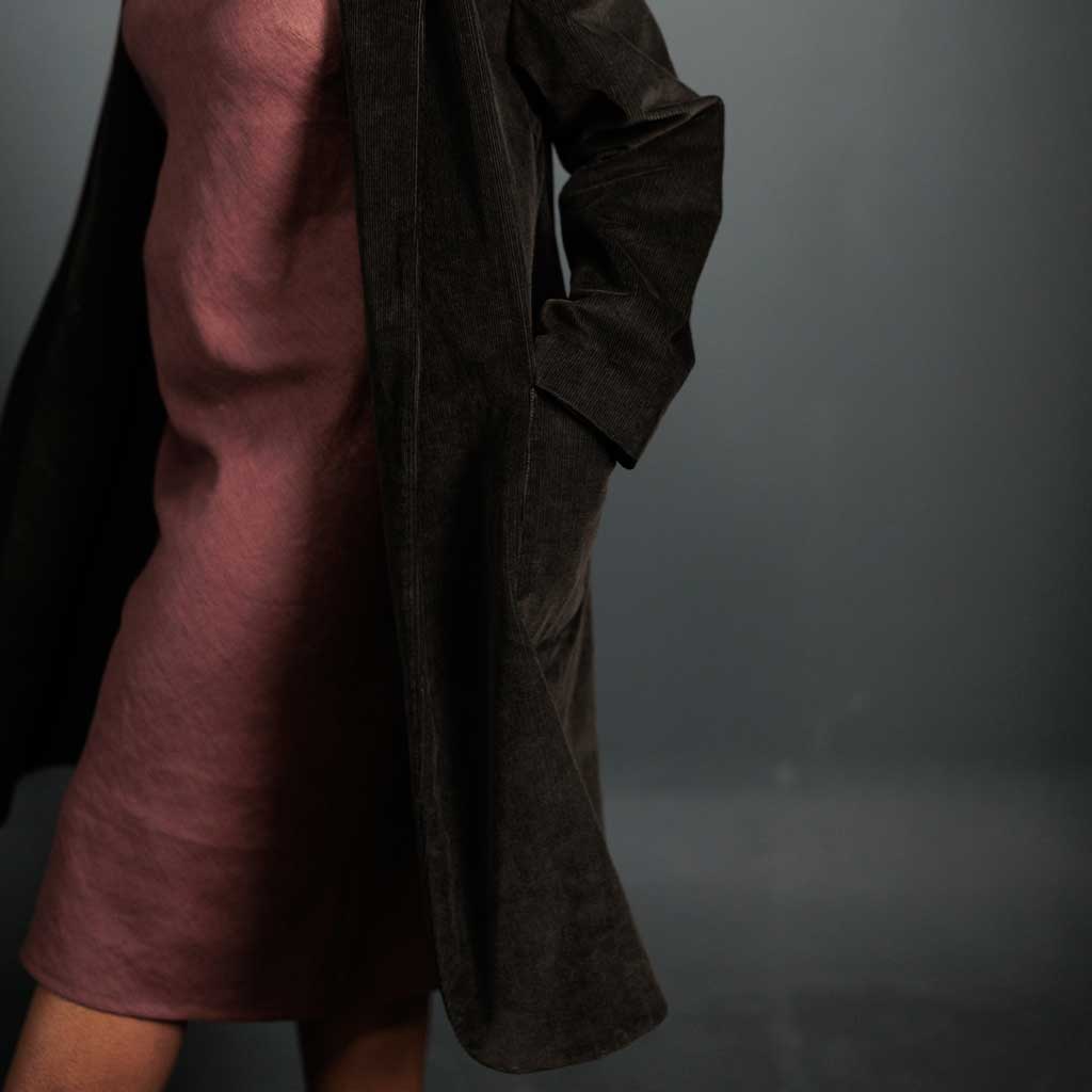 Woman wearing merchant and mills sewn clothing against dark background