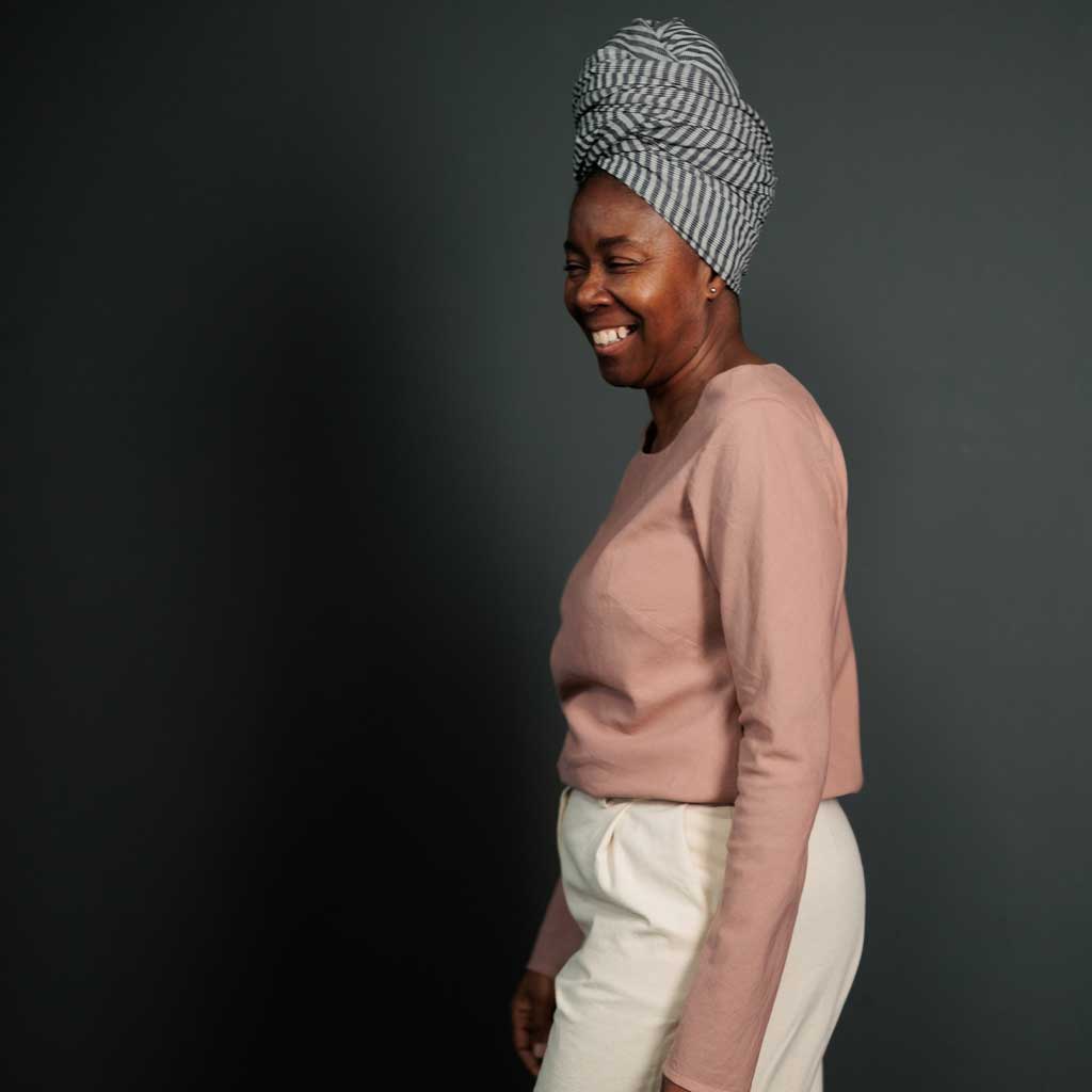 Woman wearing merchant and mills sewn clothing against dark background