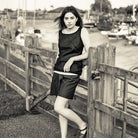 Woman wearing merchant and mills sewn clothing against boat dock background