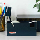 Blue desktop tape dispenser with stationery items on a white surface.