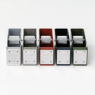 Set of five metal desk tape dispensers in different colors on a white background