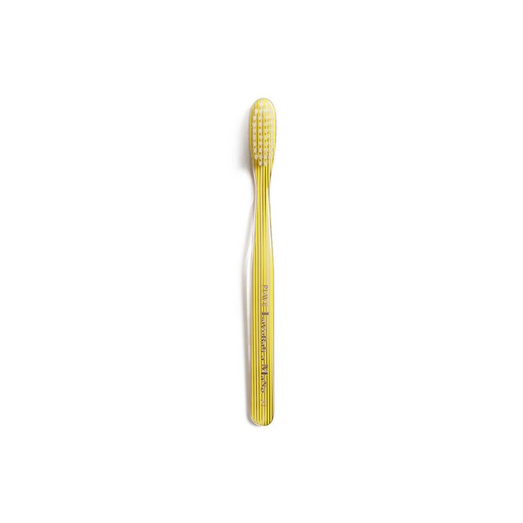 Yellow and clear striped toothbrush on white background