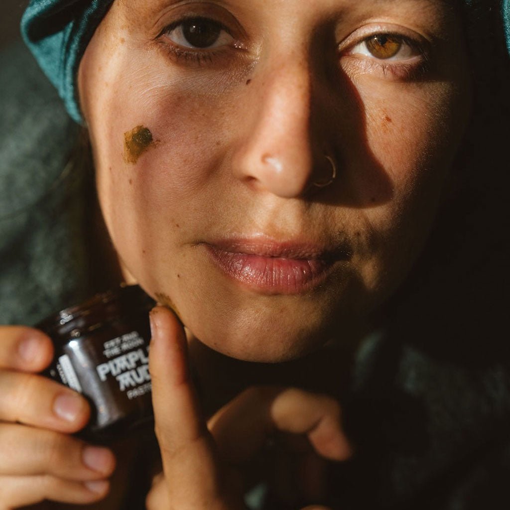 Person applying pimple mud paste to their face