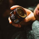 Person holding a jar of pimple mud paste
