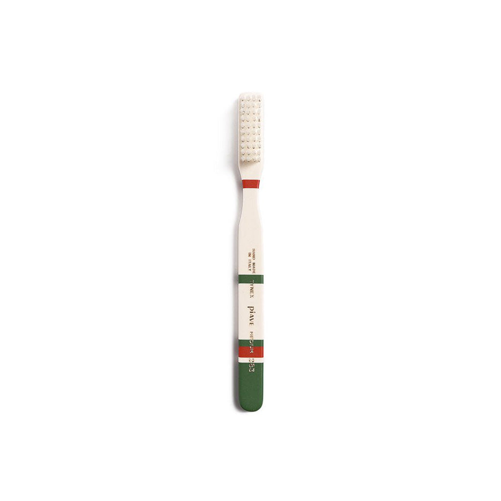 Pine green and cream toothbrush on white background