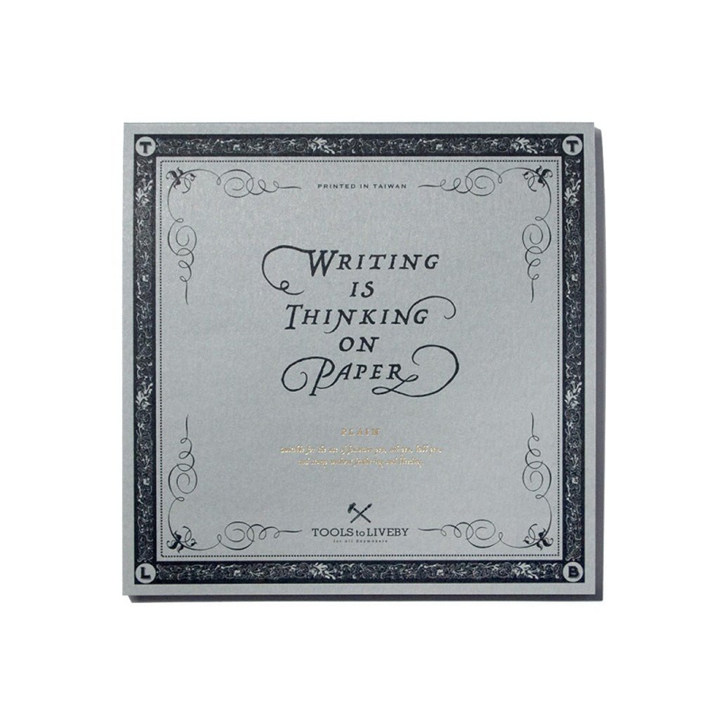 A gray square plain practice paper pad with "Writing Is Thinking On Paper" design against white background