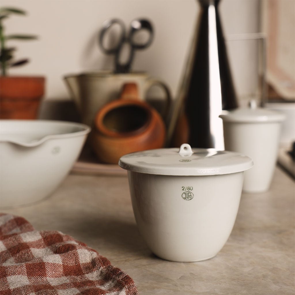 White porcelain jar with lid on kitchen counter.