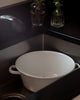 A video shows peaches being washed in an enamel colander then placed in an enamel bowl.