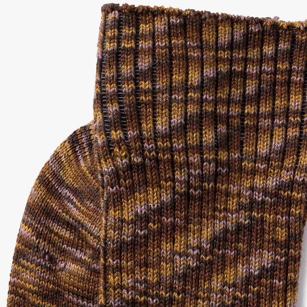 Close-up of brown multicolored socks in golden mustard, chestnut brown, dark cocoa, and soft lilac. 